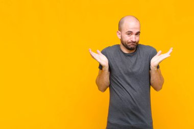 Kel adam şaşkın ve kafası karışık, şüpheci, farklı seçenekleri tartıyor ya da komik bir ifadeyle seçiyor