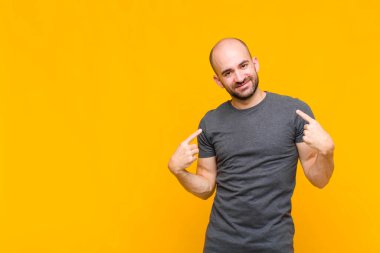 Kel adam gururlu, kibirli, mutlu, şaşırmış ve tatmin olmuş görünüyor, kendini gösteriyor, kazanan gibi hissediyor.