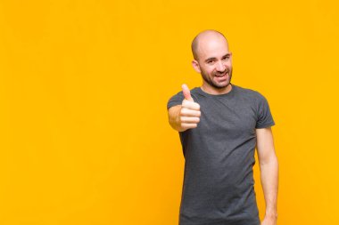 Kel adam gururlu, kaygısız, kendinden emin ve mutlu, olumlu gülümsüyor.