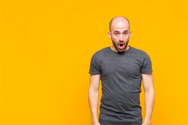 Kel adam şok olmuş ya da şaşırmış görünüyor, ağzı açık bir şekilde 