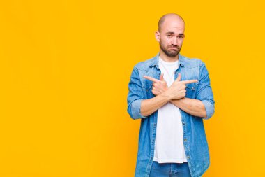 Kafası karışmış, kafası karışmış, güvensiz ve şüpheyle zıt yönlere bakan kel bir adam.