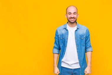 Kel adam mutlu ve şapşal görünüyor. Geniş, eğlenceli, deli gülüşü ve gözleri açık.