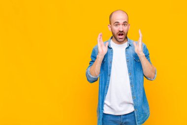 Kel adam şok olmuş ve şaşkın bakıyor, inanılmaz bir şey fark ettiğinde çenesi şaşkın şaşkın
