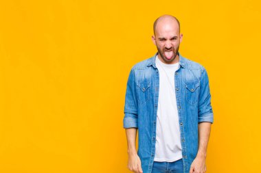 Kel adam tiksinti ve tedirginlik duyuyor, dilini dışarı çıkarıyor, iğrenç ve iğrenç bir şeyden hoşlanmıyor.