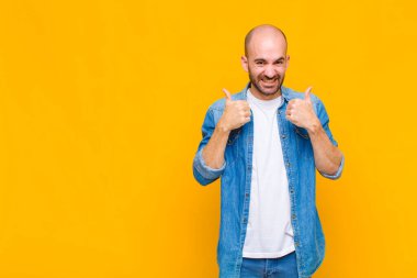 Kel adam mutlu, pozitif, kendinden emin ve başarılı bir şekilde gülümsüyor.