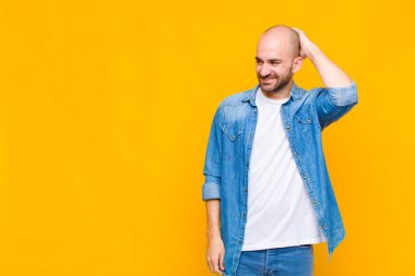 Kel adam neşeli ve sıradan bir şekilde gülümsüyor, olumlu, mutlu ve kendinden emin bir bakışla yumruk yumruğa.