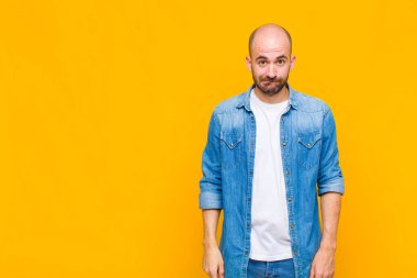 Kel adam bilgisiz, kafası karışık ve hangi seçeneği seçeceği konusunda kararsız, sorunu çözmeye çalışıyor.