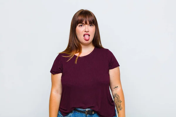 太りすぎの女性はうんざりしていらいらし舌を突き出し何かを嫌う — ストック写真
