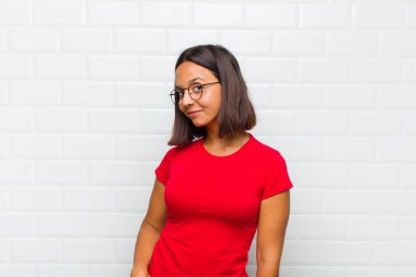 Latin kadın gururlu, kendinden emin, havalı, küstah ve küstah görünüyor, gülümsüyor, başarılı hissediyor.