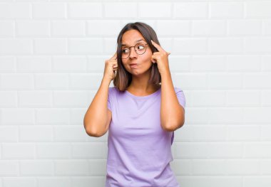 Latin kadın odaklanmış ve bir fikir üzerinde kafa yoruyor, bir meydan okumaya veya soruna bir çözüm hayal ediyor.