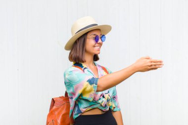 Latin kadın gülümsüyor, seni selamlıyor ve başarılı bir anlaşma için el sıkışmayı teklif ediyor.