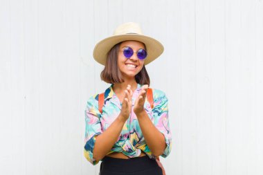 Latin kadın kendini mutlu ve başarılı hissediyor, gülümsüyor ve alkışlıyor, alkışlarla tebrik ediyor.