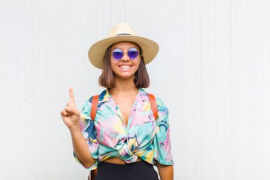 Latin kadın mutlu bir şekilde gülümsüyor, tek eliyle boşluğu dolduruyor.