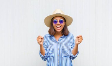 Latin kadın mutlu, şaşırmış ve gururlu hissediyor, bağırıyor ve başarıyı büyük bir gülümsemeyle kutluyor.