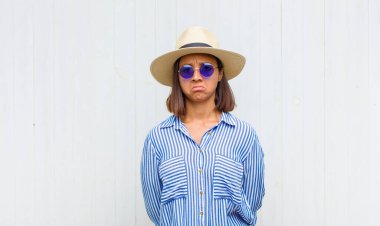 Üzgün ve mızmız bir Latin kadın, mutsuz bir bakışla, olumsuz ve hayal kırıklığına uğramış bir tavırla ağlıyor.