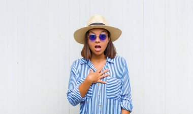 Latin kadın şok olmuş ve şaşırmış hissediyor, gülümsüyor, el ele tutuşuyor, o olmaktan mutlu ya da minnettarlık gösteriyor.