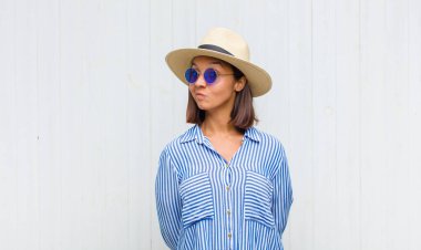 Latin kadın kendini şaşkın ve şüpheli hissediyor, merak ediyor ya da karar vermeye çalışıyor.