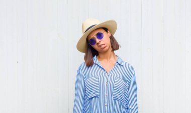 latin woman feeling puzzled and confused, with a dumb, stunned expression looking at something unexpected