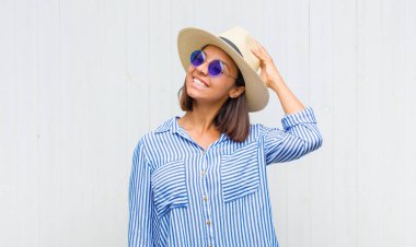 Latin kadın neşeli ve rahat bir şekilde gülümsüyor, olumlu, mutlu ve kendinden emin bir bakışla yumruk yumruğa.