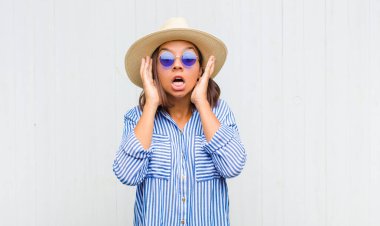 Latin kadın dehşete kapılmış ve şok olmuş hissediyor, ellerini havaya kaldırıyor ve bir hata yüzünden panikliyor.