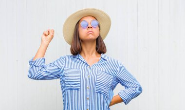 Latin kadın kendini ciddi, güçlü ve asi hissediyor, yumruğunu kaldırıyor, protesto ediyor ya da devrim için savaşıyor.