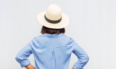 Latin bir kadın kendini kafası karışık ya da dolu hissediyor ya da şüphe ve sorular, merak ediyor, elleri kalçasında, dikiz aynasından