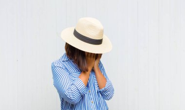 Üzgün, hayal kırıklığına uğramış bir bakışla gözlerini kapayan Latin kadın. Ağlıyor, yan gözle bakıyor.