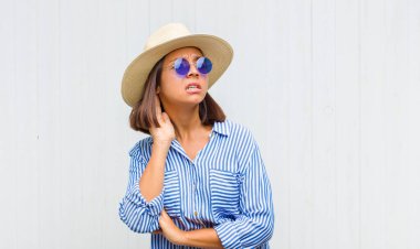 Latin kadın ciddi ve meraklı görünüyor, dinliyor, gizli bir konuşma veya dedikodu duymaya çalışıyor, kulak misafiri oluyor.