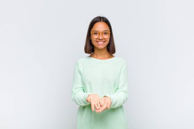 Latin kadın mutlu bir şekilde gülümsüyor arkadaş canlısı, kendinden emin, olumlu bakışlı, bir nesne ya da konsept sunuyor ve gösteriyor