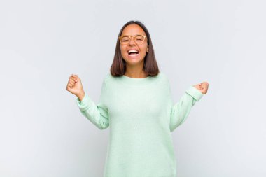 Latin kadın son derece mutlu ve şaşırmış görünüyor, başarıyı kutluyor, bağırıyor ve zıplıyor.