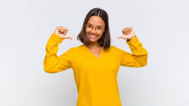 Latin kadın gururlu, kibirli ve kendinden emin, tatmin olmuş ve başarılı görünüyor, kendini işaret ediyor.