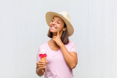 Genç İspanyol kadın mutlu bir şekilde gülümsüyor ve hayal kuruyor ya da şüphe ediyor.