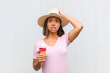 Genç İspanyol kadın kendini stresli, endişeli, endişeli ya da korkmuş hissediyor. Elleri başının üstünde, hatayla panikliyor.