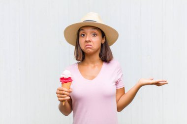 Genç İspanyol kadın şaşkın ve kafası karışık, şüpheci, farklı seçenekleri tartıyor veya komik bir ifadeyle seçiyor.