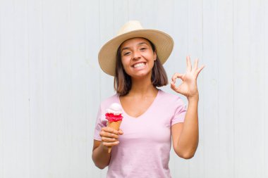 Genç İspanyol kadın kendini mutlu, rahat ve tatmin olmuş hissediyor. Onayını iyi bir hareketle gösteriyor. Gülümsüyor.