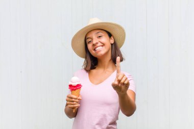 Genç İspanyol kadın gururla ve kendinden emin bir şekilde gülümsüyor. Bir numaralı pozu başarıyla veriyor. Kendini lider gibi hissediyor.