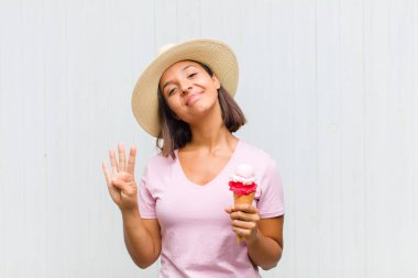 Genç İspanyol kadın gülümsüyor ve arkadaş canlısı görünüyor. Elleri önde, geriye doğru sayıyor.