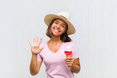 Genç İspanyol kadın gülümsüyor ve arkadaş canlısı görünüyor, 5 ya da 5 numarayı gösteriyor, elleri önde, geriye doğru sayıyor