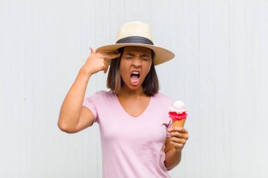 Genç İspanyol kadın mutsuz ve stresli görünüyor, intihar jesti elle silah işareti yapıyor, kafasını işaret ediyor.