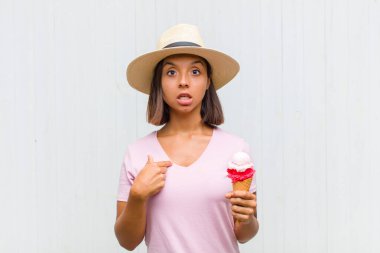 Şok olmuş ve ağzı açık, kendini işaret eden genç İspanyol bir kadın.