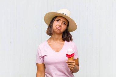 Genç İspanyol kadın üzgün ve mızmızlanıyor, mutsuz bir bakışla, negatif ve hayal kırıklığına uğramış bir tavırla ağlıyor.