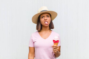 Genç İspanyol kadın tiksinti ve tedirginlik duyuyor, dilini dışarı çıkarıyor, iğrenç ve iğrenç bir şeyden hoşlanmıyor.