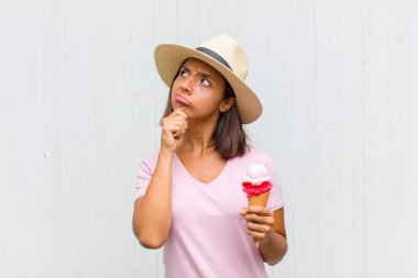 Genç İspanyol kadın düşünüyor, kuşkulu ve şaşkın hissediyor, farklı seçeneklerle, hangi kararı vereceğini merak ediyor.