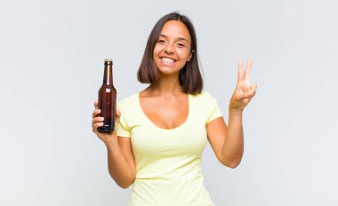 Genç İspanyol kadın gülümsüyor ve mutlu görünüyor, kaygısız ve pozitif, zafer ya da barışı simgeliyor.