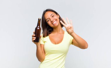 Genç İspanyol kadın gülümsüyor ve arkadaş canlısı görünüyor. Elleri önde, geriye doğru sayıyor.