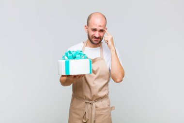 Genç kel adam kafası karışık ve şaşkın hissediyor. Deli, deli ya da aklını kaçırmış olduğunu gösteriyor.