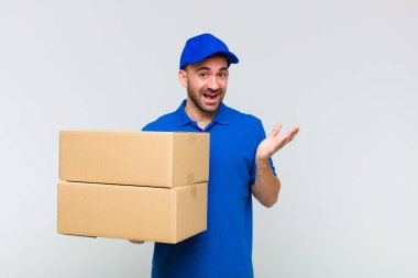 Genç kel adam mutlu, şaşırmış ve neşeli hissediyor, pozitif bir tavırla gülümsüyor, bir çözüm ya da fikir buluyor.