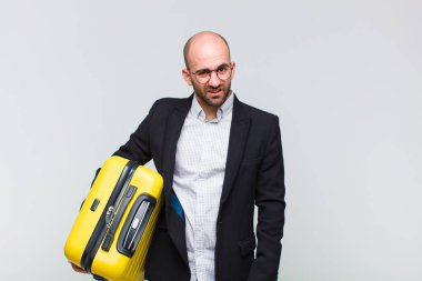 young bald man feeling puzzled and confused, with a dumb, stunned expression looking at something unexpected