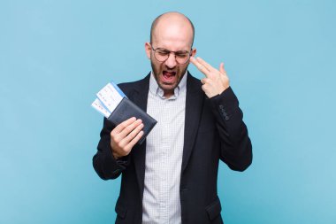 Genç kel adam mutsuz ve stresli görünüyor, intihar jesti elle silah işareti yapıyor, kafasını işaret ediyor.