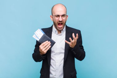 Genç kel adam umutsuz ve sinirli görünüyor, stresli, mutsuz ve sinirli, bağırıyor ve çığlık atıyor.